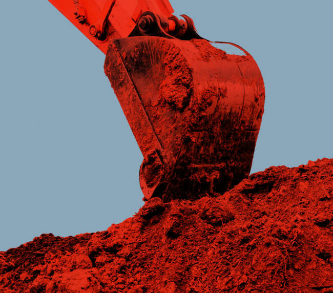 Excavator bucket digs clay soil