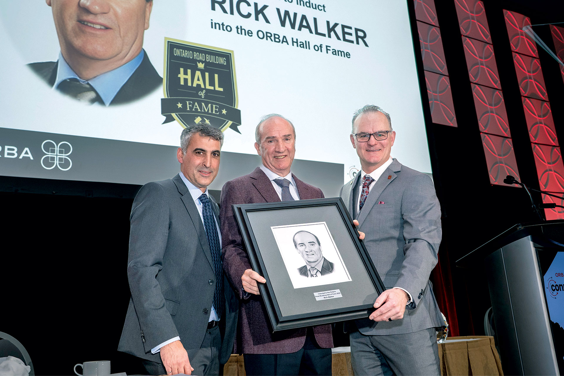 Malcolm Croskery, Rick Walker and Mark Mallett on stage with award