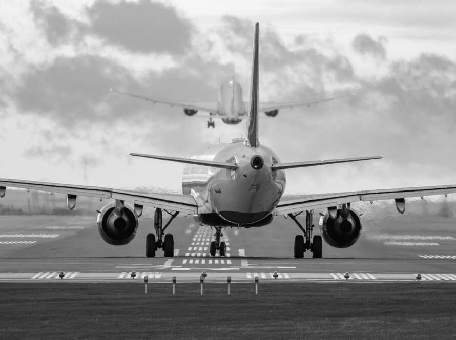 MISSISSAUGA, CANADA – OCTOBER 20, 2025: A rear view of a commercial passenger jet airliner lined up on the runway for departure at Toronto Pearson International Airport (YYZ), while another aircraft climbs into the morning sky directly ahead. The extreme 600mm telephoto perspective creates a dramatic compression effect between the two planes.