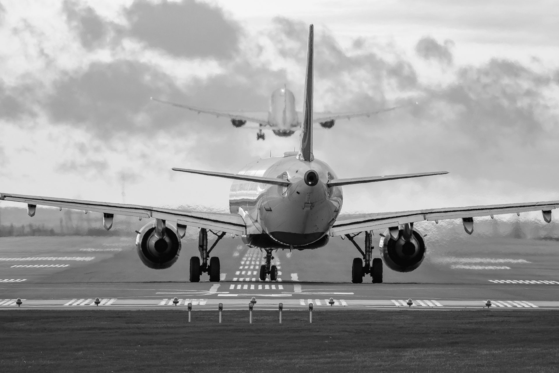 MISSISSAUGA, CANADA – OCTOBER 20, 2025: A rear view of a commercial passenger jet airliner lined up on the runway for departure at Toronto Pearson International Airport (YYZ), while another aircraft climbs into the morning sky directly ahead. The extreme 600mm telephoto perspective creates a dramatic compression effect between the two planes.