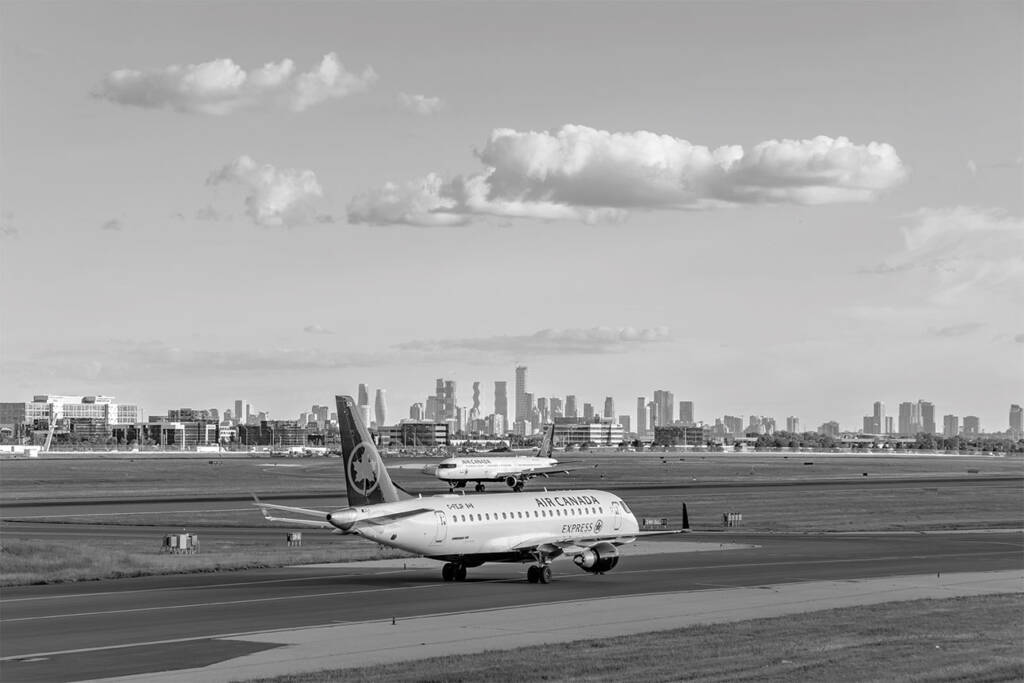 MISSISSAUGA, ONTARIO, CANADA - JUNE 24, 2026: Two Air Canada passenger aircraft taxi at Toronto Pearson airport before the skyline.